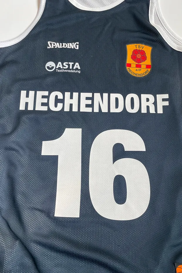 Schwarzes Basketballtrikot mit der Aufschrift "HECHENDORF" und der Nummer "16".